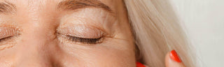 Close-up of mature woman's closed eye and silver hair, symbolizing graceful aging and skincare focus for longevity.