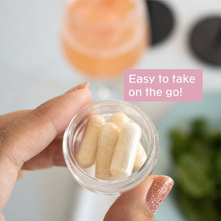 Hand holding a container of Dihydromyricetin capsules, emphasizing easy use on the go.