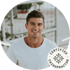 Smiling certified chiropractor in a casual white shirt, promoting health and wellness.