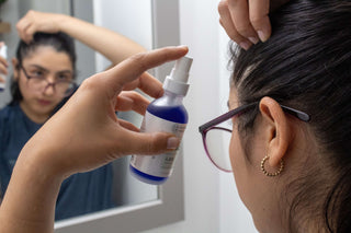 Woman spraying  AHK-Cu Hair Elixir Expert to scalp.