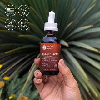 Fulvic Acid Drops bottle held in front of green agave leaves with icons: Made in USA, vegan, lab tested, non-GMO.