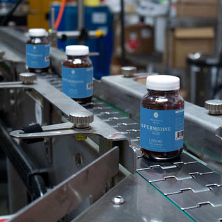 Spermine bottles on a production line, showcasing 1200 mg dietary supplement in a factory setting.