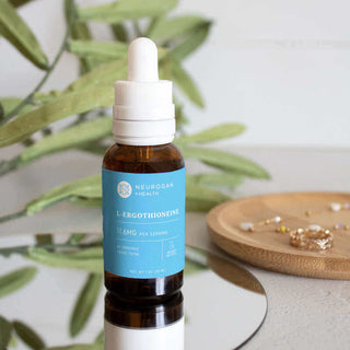 Neurogan Health L-Ergothioneine supplement bottle on a table with greenery and jewelry.