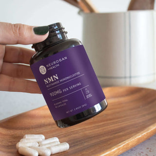 NMN bottle on a wooden tray with capsules, highlighting daily cellular energy and bioavailability benefits*.