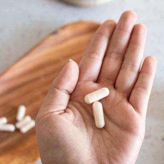 Close-up of NMN capsules in hand, showcasing capsule size and easy dosing for cellular energy and aging support*.