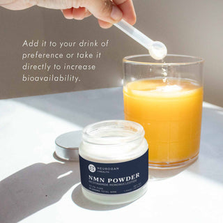 Scoop of NMN Powder being added to a glass of orange juice for increased bioavailability.