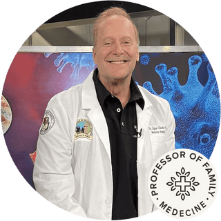 Smiling professor in a white lab coat, standing in front of a colorful medical backdrop with virus imagery.