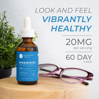 Spermidine Drops 2400mg bottle on a table with glasses, promoting 20mg per serving and 60-day supply.