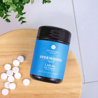 Neurogan Spermidine tablets in a blue container on a wooden surface with white tablets beside it.