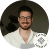 Smiling male massage therapist with glasses, promoting relaxation and wellness.