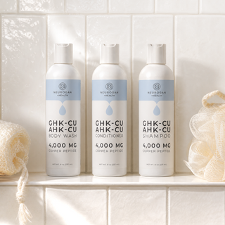 GHK-Cu and AHK-Cu copper peptide shampoo, conditioner and body wash on a shower shelf