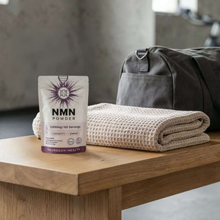 NMN Powder on a wooden table next to a rolled towel and gym bag, promoting healthy aging and fitness.