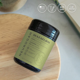 Deazaflavin supplement bottle on wooden table with icons for vegan, non-GMO, and lab tested.