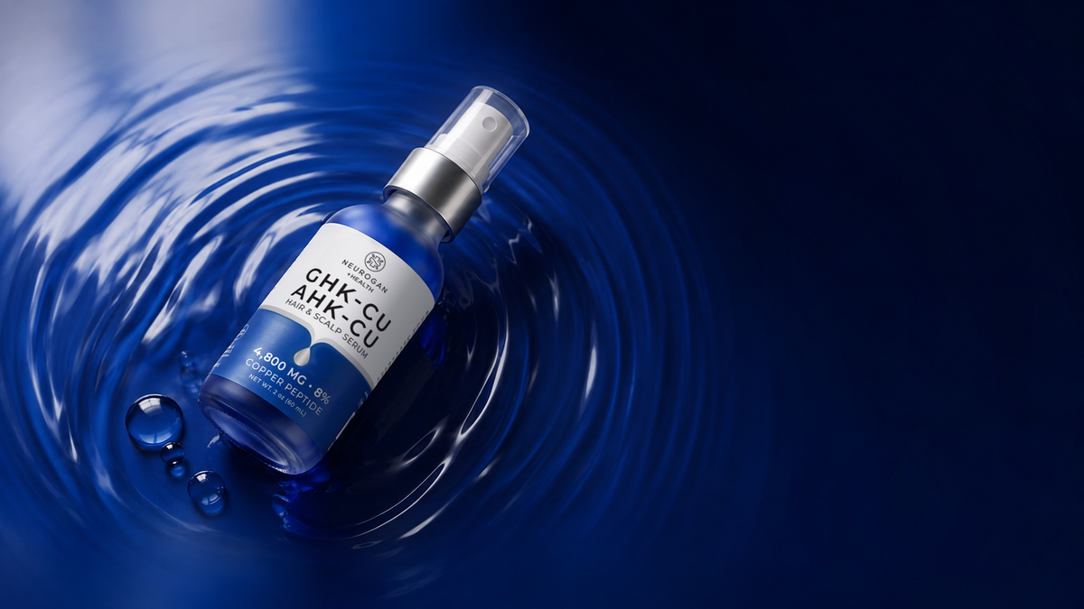 AHK-Cu + GHK-Cu Hair Serum Pro spray bottle resting in rippled blue liquid