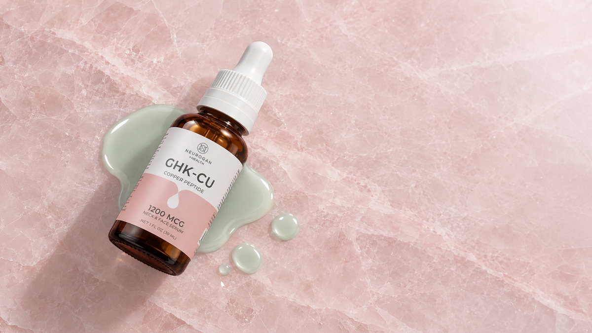 GHK-Cu Neck & Face Serum amber dropper bottle on pink marble beside a pool of serum
