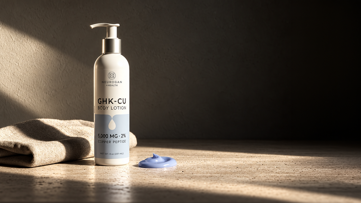 GHK-Cu Body Lotion pump bottle on a travertine vanity in morning light, beside a linen towel and a swirl of blue lotion