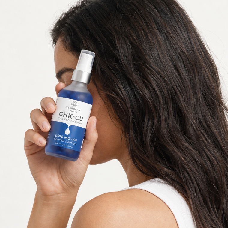 Holding the GHK-Cu Hair & Scalp Serum bottle beside the hair
