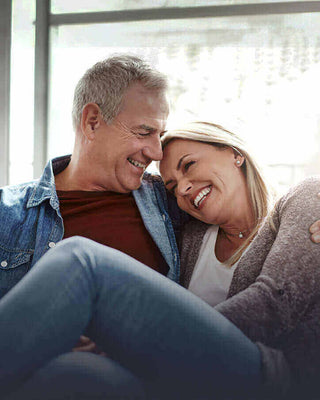 Smiling couple enjoying quality time together at home, showcasing love and affection in a cozy setting.