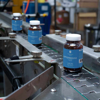 Spermine bottles on a production line, showcasing 1200 mg dietary supplement in a factory setting.