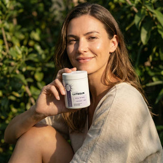 A woman holding a jar of Liposomal Luteolin in a natural setting, highlighting antioxidant support and cellular protection.