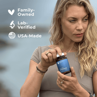 Woman holding Liposomal Spermidine Capsules with labels: Family-Owned, Lab-Verified, USA-Made.