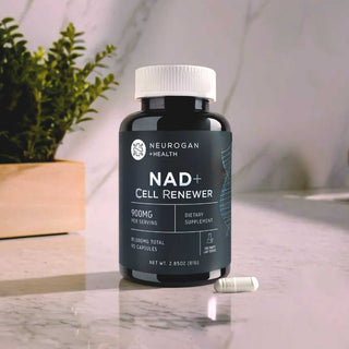 NAD+ Cell Renewer bottle with 900mg per serving, placed on a marble counter beside capsules and a potted plant.