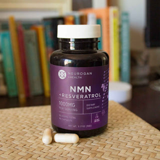 NMN + Resveratrol Capsules, 1000mg per serving, bottle on a woven mat with two capsules beside it, indoors.