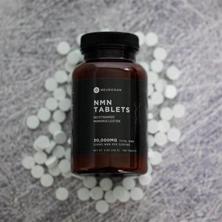 NMN Tablets in a dark brown bottle, 30,000mg total NMN, 500mg per serving, surrounded by white tablets.