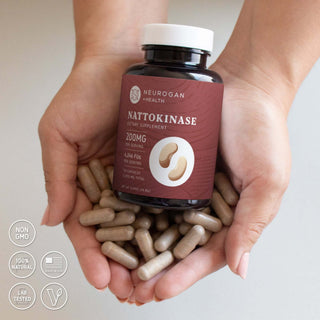 Nattokinase Capsules in hands with label indicating 2000MG dietary supplement, non-GMO and lab tested.