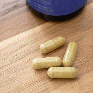 Fisetin capsules on wooden table, showcasing natural dietary supplement for memory and cellular repair.