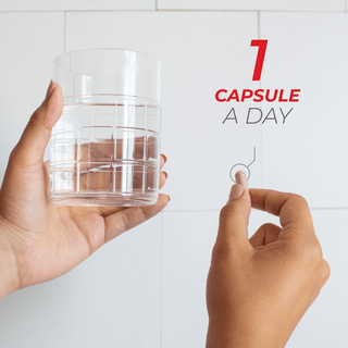 Hand holding Urolithin A capsule and glass of water, promoting daily dosage of one capsule.